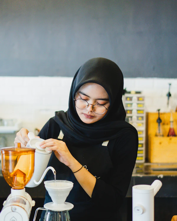 Café owner preparing coffee behind her counter